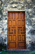 Ornate Wooden Mission Doors / interesting view of an old, large, ornate wooden doors standing against an worn masonry wall