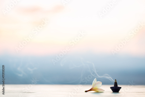 Fotografía Conos de incienso de humo con Plumeria flor en la puesta del sol