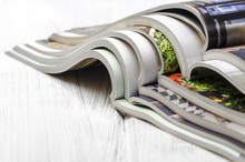 Stack Of Magazines On A White Wooden Background