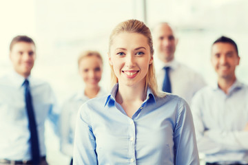 Canvas Print - smiling businesswoman with colleagues in office