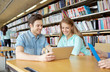 © Syda Productions - happy students with tablet pc in library