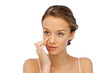 © Syda Productions - young woman applying cream to her face