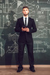 © kanashkin - A bearded man in a suit standing with tablet near whiteboard with graphs