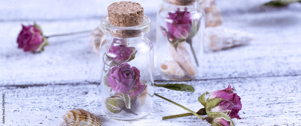 Fotovorhang - Small glass bottle filled dry roses and seashells