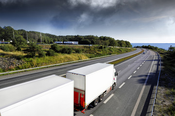 Poster - trucking on scenic freeway/motorway, dark storm clouds approaching