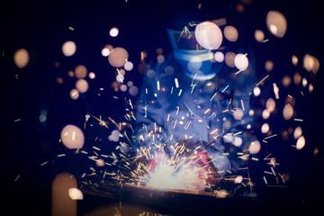 Employee welding steel with sparks using mig mag welder - focus on sparks.