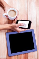 Poster - Businesswoman holding smartphone and coffee cup