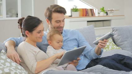 Wall Mural - Family with baby in sofa watching tv 