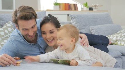 Wall Mural - Parents enjoying playing with baby girl