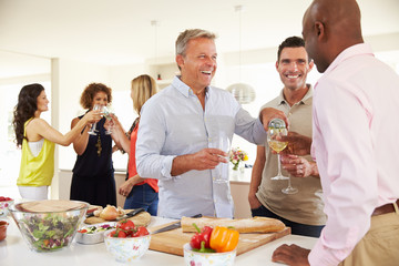 Wall Mural - Group Of Mature Friends Enjoying Dinner Party At Home