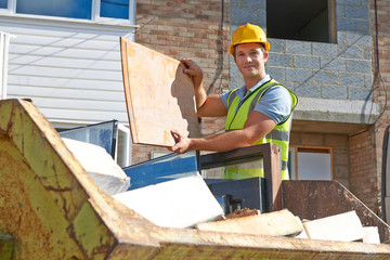 Builder Putting Waste Into Rubbish Skip