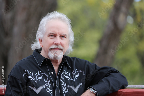 Outdoor Photo Of Silver Haired Male Model Wearing Black Western