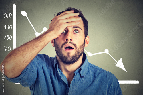 Cuadros en Lienzo stressed shocked business man with financial market chart graphic going down