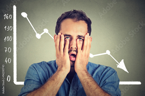 Cuadros en Lienzo frustrated stressed young man desperate with financial market chart graphic goin