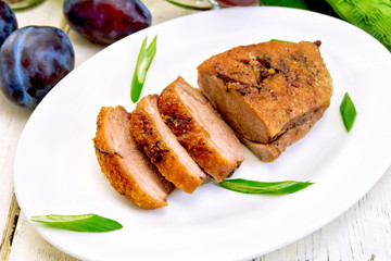 Duck breast with plum sauce and green onions in white plate