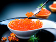 Caviar. Red caviar in spoon on a black background