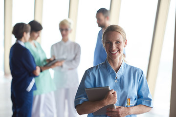 Canvas Print - female doctor with tablet computer  standing in front of team