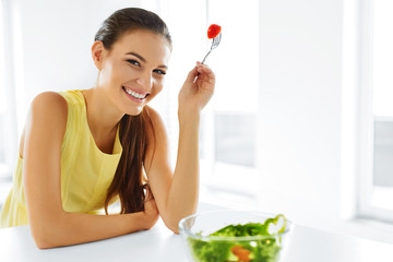 Wall Mural - Healthy Eating. Close Up Portrait Of Young Smiling Vegetarian Woman Eating Fresh Healthy Vegetable Salad In Modern Kitchen. Healthy Food, Lifestyle Concept. Health, Dieting, Diet. Nutrition.