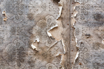 aged room wall background with torn vintage wallpaper.