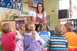 © highwaystarz - Group Of Pre School Children Listening To Teacher Reading Story