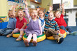 Group Of Pre School Children Answering Question In Classroom