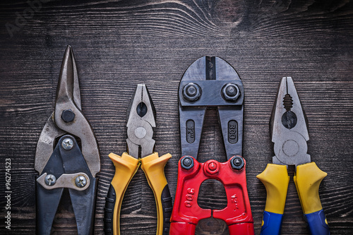 Sharp tin snips steel cutter pliers on wooden board Tableau sur Toile