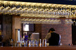 © MaxK - Group of empty wine glasses hanging from metal beams in a bar