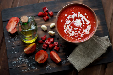 Wall Mural - Gazpacho soup on a rustic wooden chopping board, high angle view