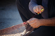 Fisherman Repairs The Fishing Nets