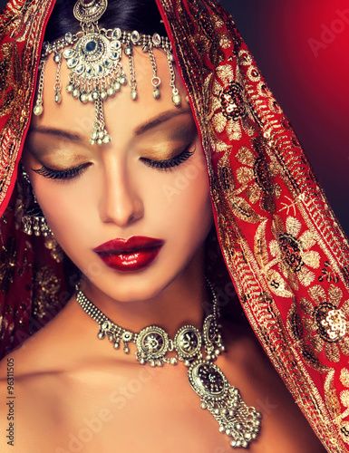 Naklejka ścienna Beautiful Indian women portrait with jewelry. elegant Indian girl , bollywood style . Indian jewelry with dark skin model . Beautiful brunette asian girl with black veil on face 