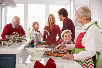 Extended Family Group Preparing Christmas Meal In Kitchen