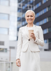 Canvas Print - smiling businesswoman with paper cup outdoors