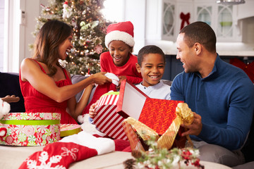 Family Opening Christmas Presents At Home Together