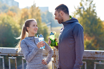 Sticker - smiling couple with bottles of water outdoors