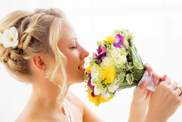 Bride smelling her wedding flowers