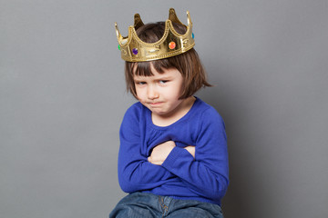 spoiled kid concept - funny preschool child with golden crown on head folding arms for suspicious mollycoddled little king or queen metaphor,studio shot