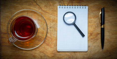 Small notebook with a Cup of tea, stick on a rustic wood backgro