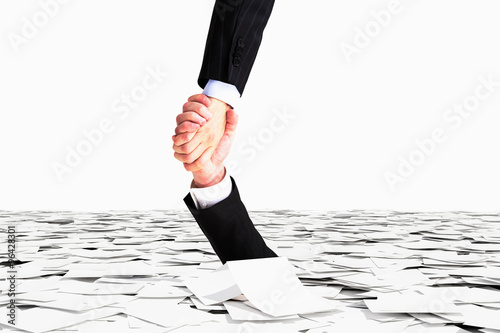 Fotografía One hand helps no to sink in the sea of paper, bureaucracy conce
