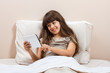 © inesbazdar - Little girl using digital tablet in bed