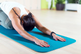 Fit woman doing stretching pilates exercises in fitness studio.