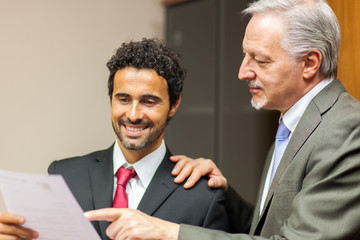 Poster - Two business colleagues reading a document in an office