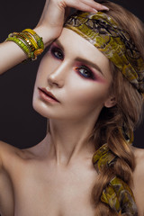 Beautiful fashion girl in a scarf and bracelets boho style. Beauty face, bright trendy makeup