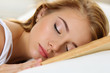 Young beautiful blonde woman portrait lying in bed