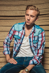 Poster - boy sitting in studio background while posing looking down