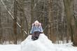 © nkarol - Smiling little girl wearing warm clothes posing on snowy hill in winter forest