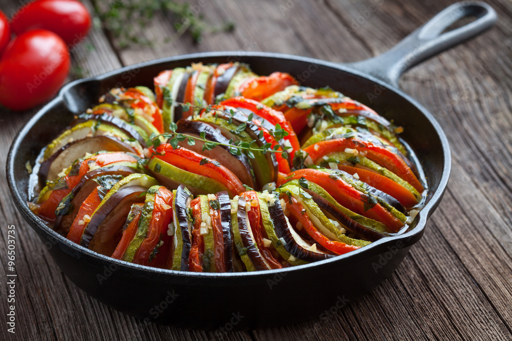 Obraz na płótnie Traditional homemade vegetable ratatouille baked in cast iron frying pan healthy diet french vegetarian food on vintage wooden table background w salonie