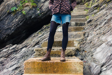 Wall Mural - Young woman standing on steps in nature