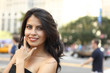 © DW labs Incorporated - Woman smiles with hand to her face looking at viewer.