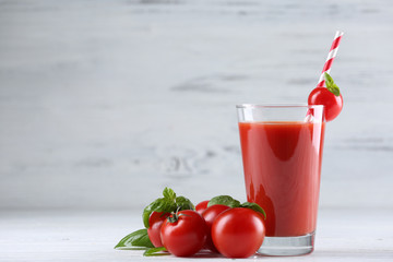Wall Mural - Glass of tomato juice with vegetables on wooden background