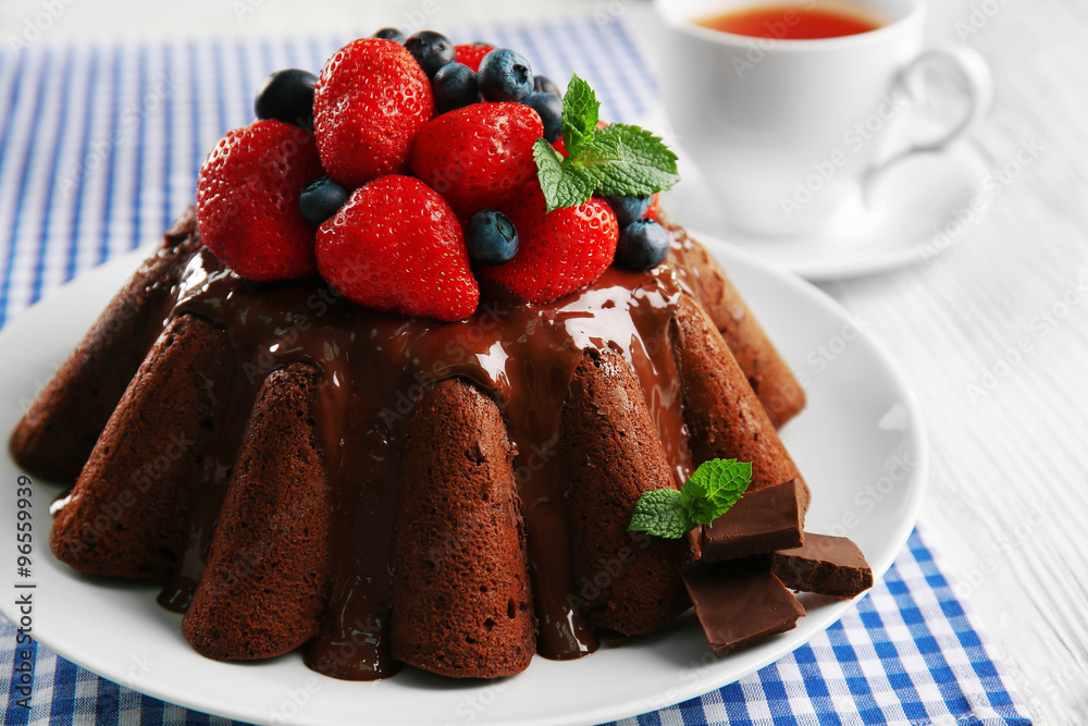 Delicious chocolate cake with strawberries in plate on table, closeup